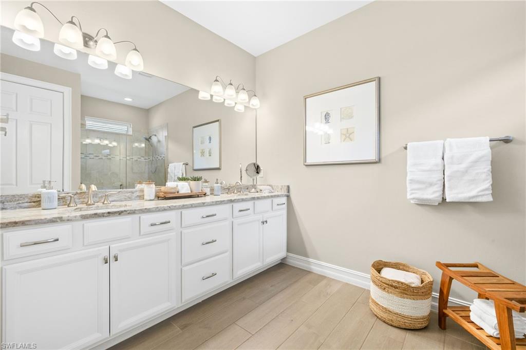 14546 Tropical Drive Naples, FL 34114 - Photo 16 of 38 a spacious bathroom with a granite countertop sink a toilet and a mirror