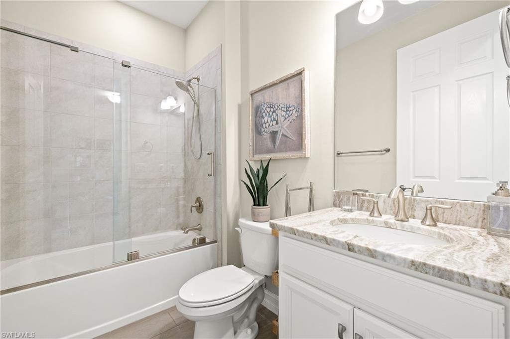 14546 Tropical Drive Naples, FL 34114 - Photo 20 of 38 a bathroom with a granite countertop sink a toilet and shower