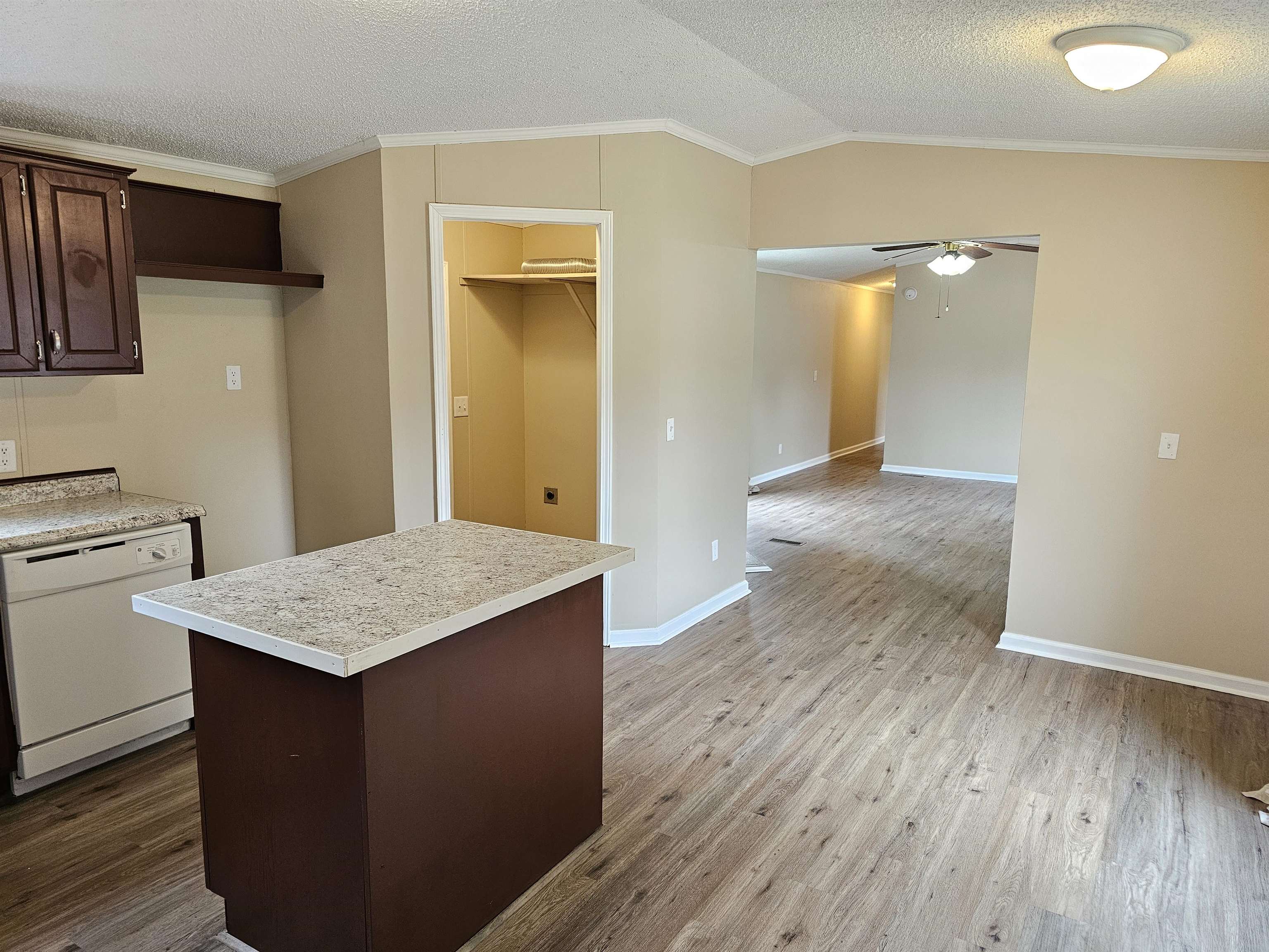 474 Fite Road Munford, TN 38058 - Photo 6 of 19 Kitchen with crown molding, white dishwasher, light countertops, dark brown cabinetry, and vaulted ceiling