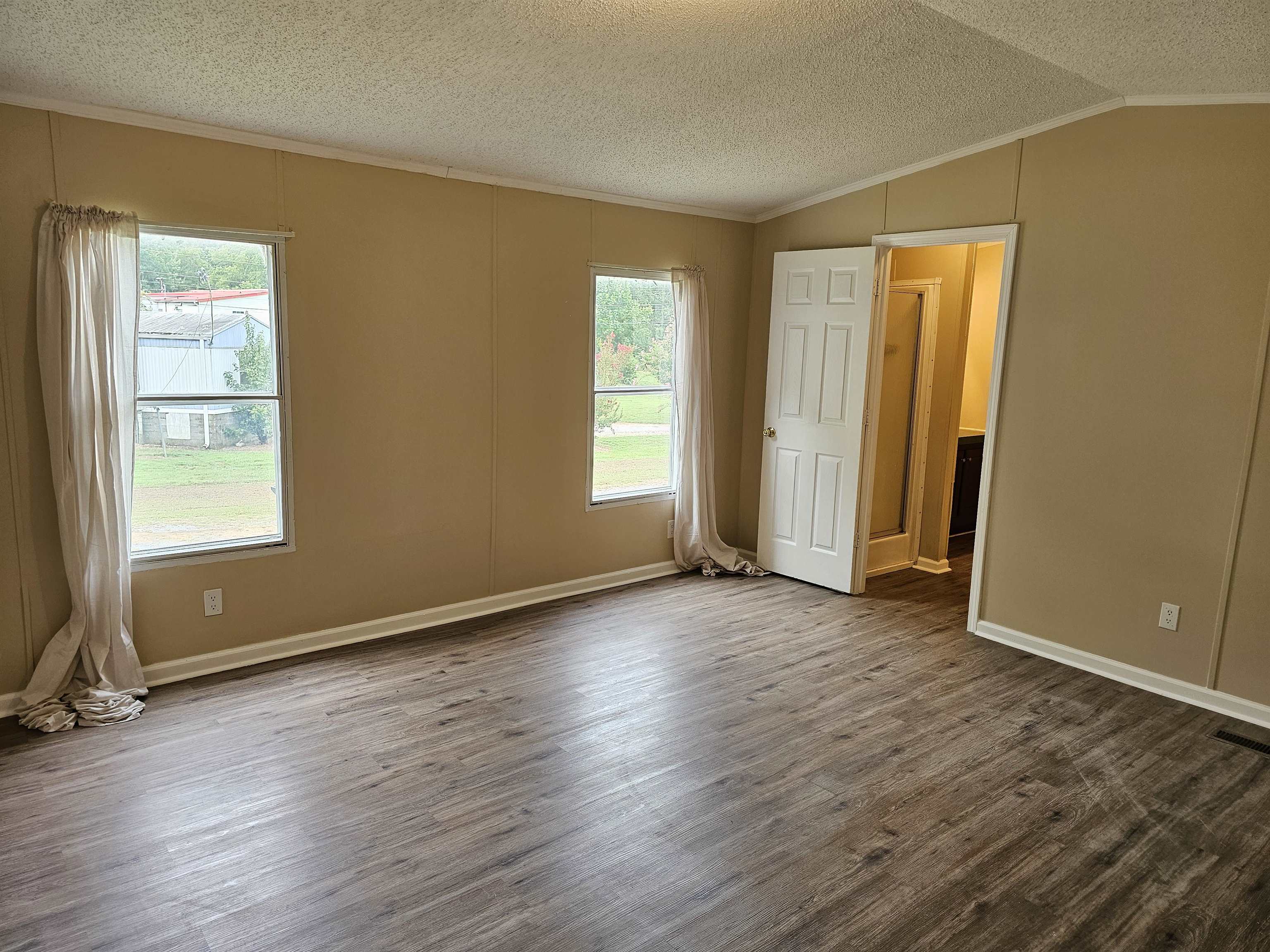 474 Fite Road Munford, TN 38058 - Photo 8 of 19 Empty room with dark wood finished floors, ornamental molding, a textured ceiling, and vaulted ceiling