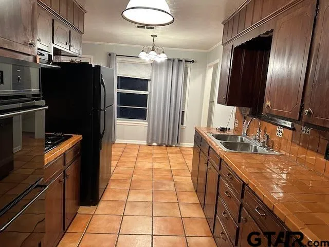 a kitchen with stainless steel appliances granite countertop a refrigerator a sink and dishwasher