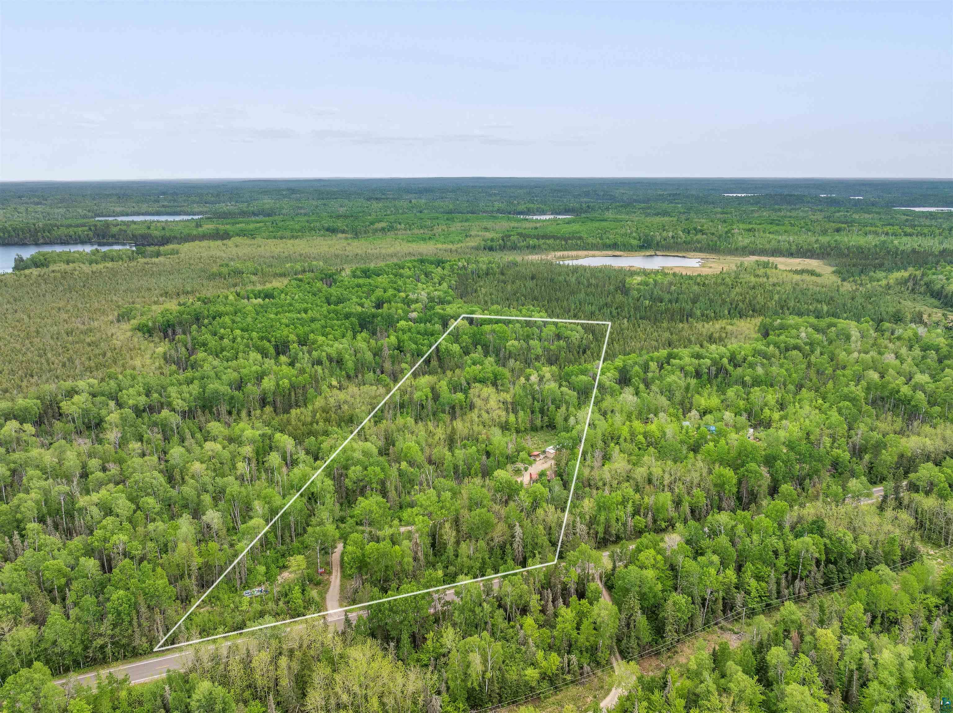 1152 Fernberg Road Ely, MN 55731 - Photo 23 of 24 Expansive wooded lot outlined, featuring a visible road frontage and surrounded by additional natural forested areas