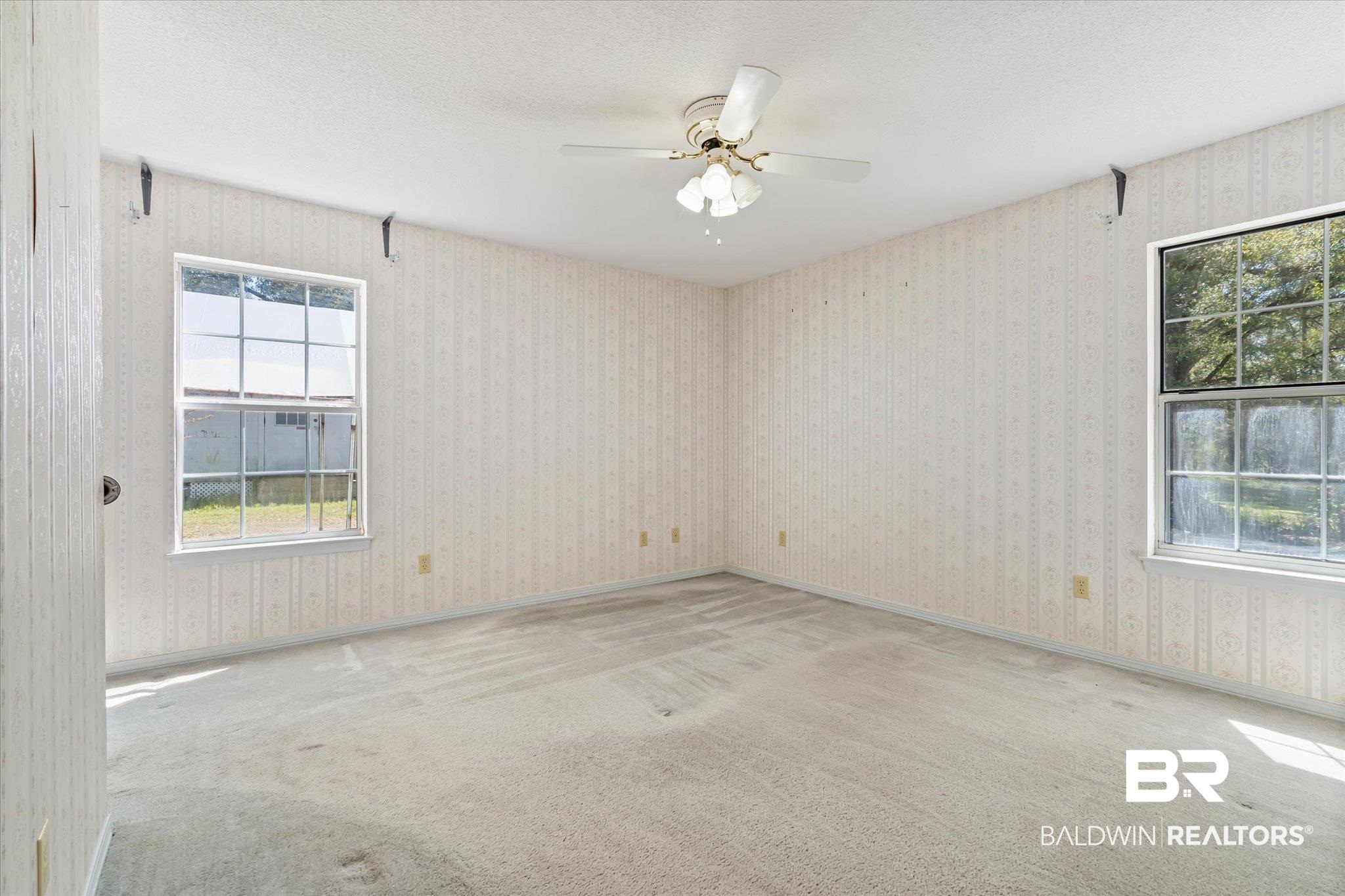 6030 Lott Road Eight Mile, AL 36613 - Photo 9 of 21 Carpeted spare room with baseboards, a textured ceiling, wallpapered walls, and a healthy amount of sunlight