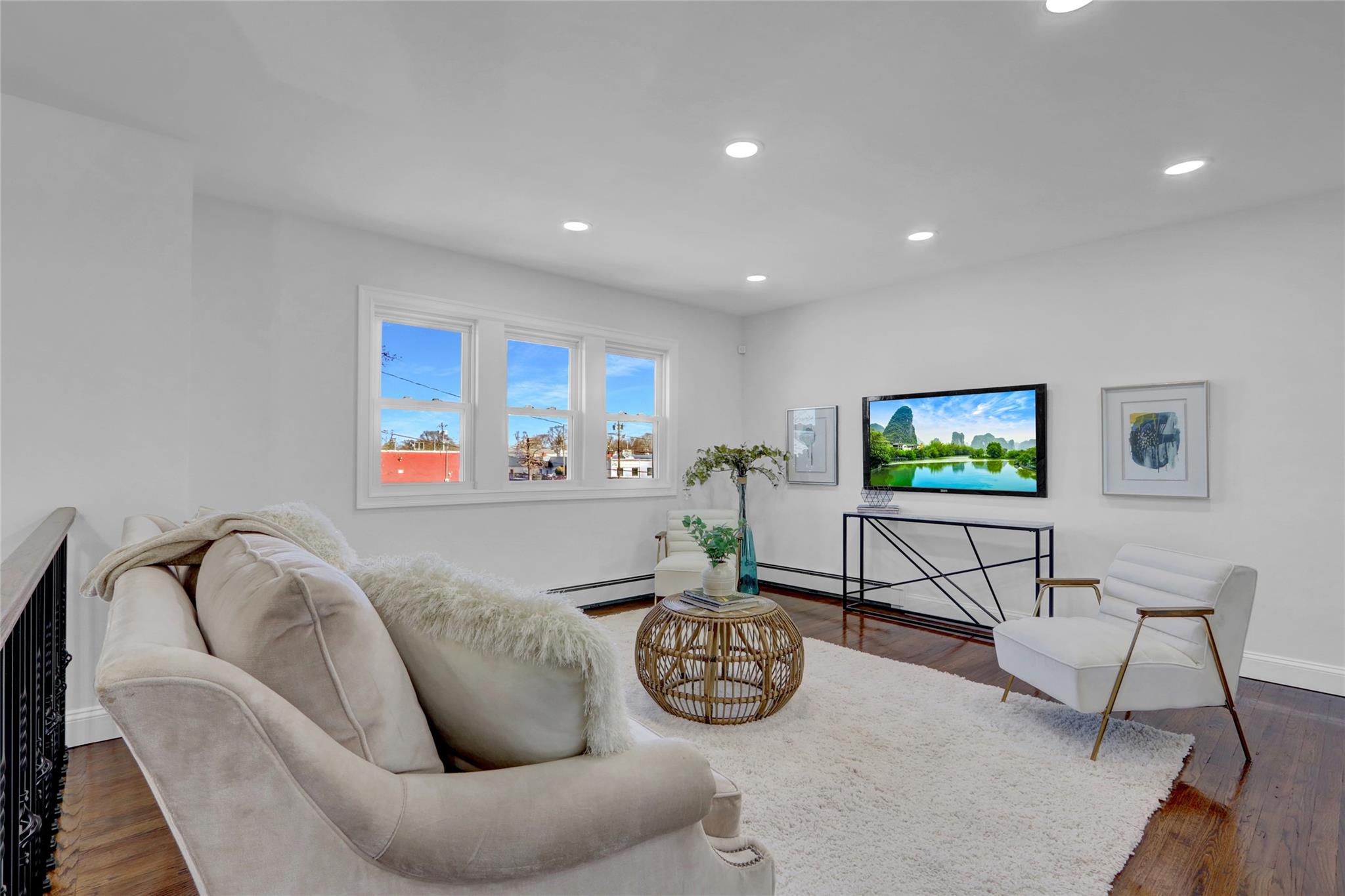 Living area featuring dark wood-type flooring, baseboards, and recessed lighting