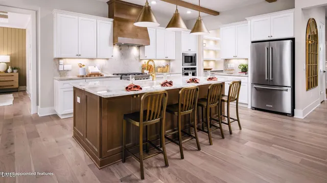 a kitchen with stainless steel appliances a table chairs refrigerator and wooden floor