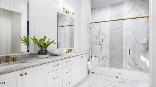 a bathroom with a granite countertop sink a mirror a potted plant and a shower