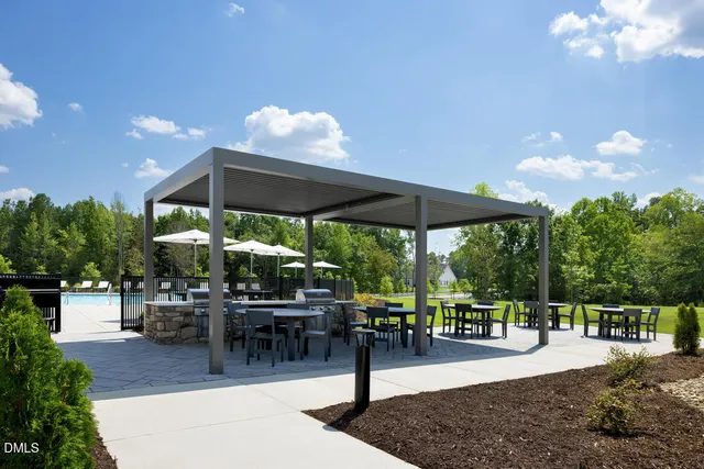 a view of a patio with a dining table and chairs with a small yard