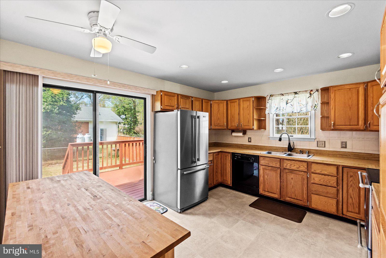121 11th Street Colonial Beach, VA 22443 - Photo 12 of 33 a kitchen with stainless steel appliances granite countertop a refrigerator a sink dishwasher a stove and white countertops with wooden floor