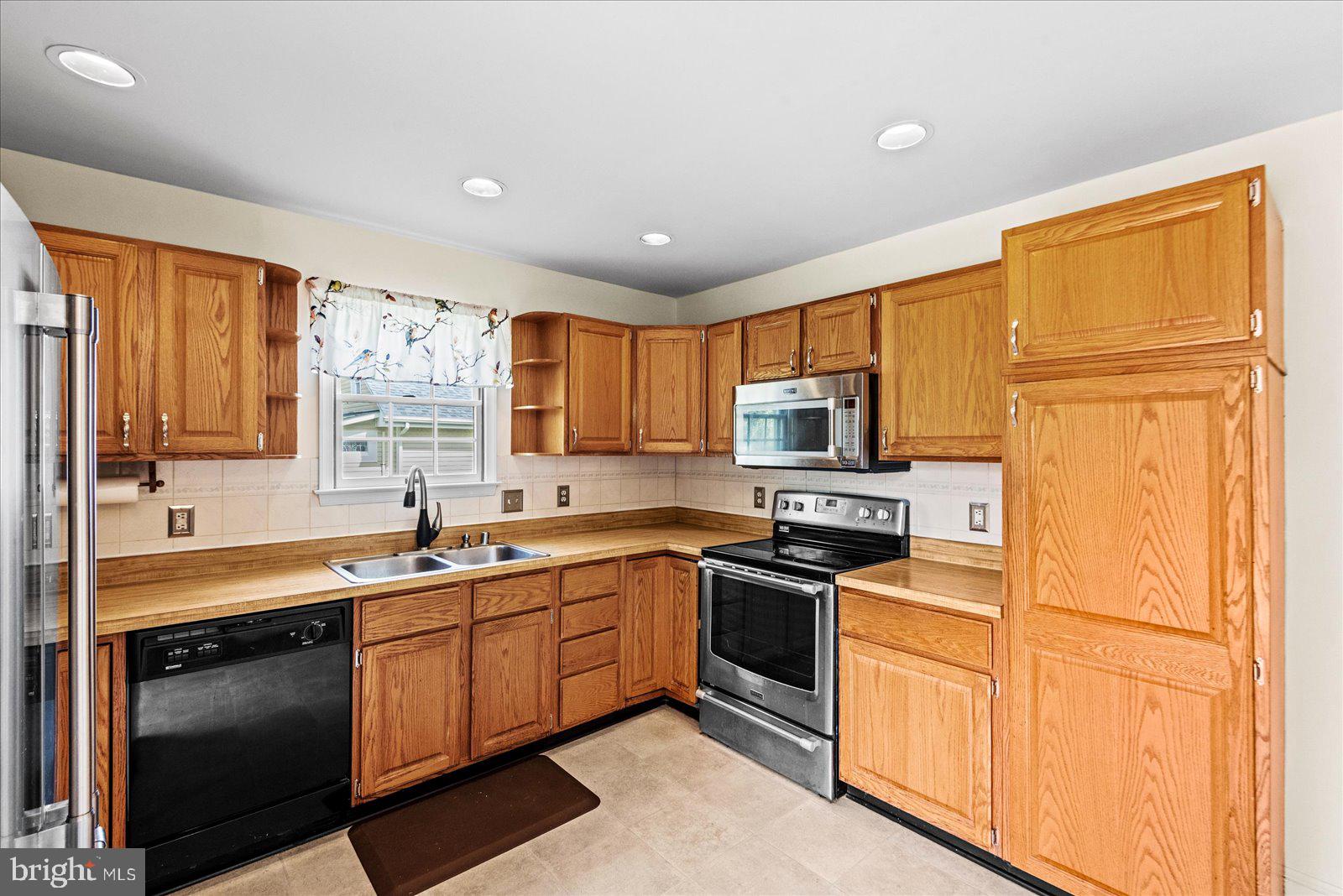 121 11th Street Colonial Beach, VA 22443 - Photo 13 of 33 a kitchen with stainless steel appliances granite countertop a sink stove and refrigerator