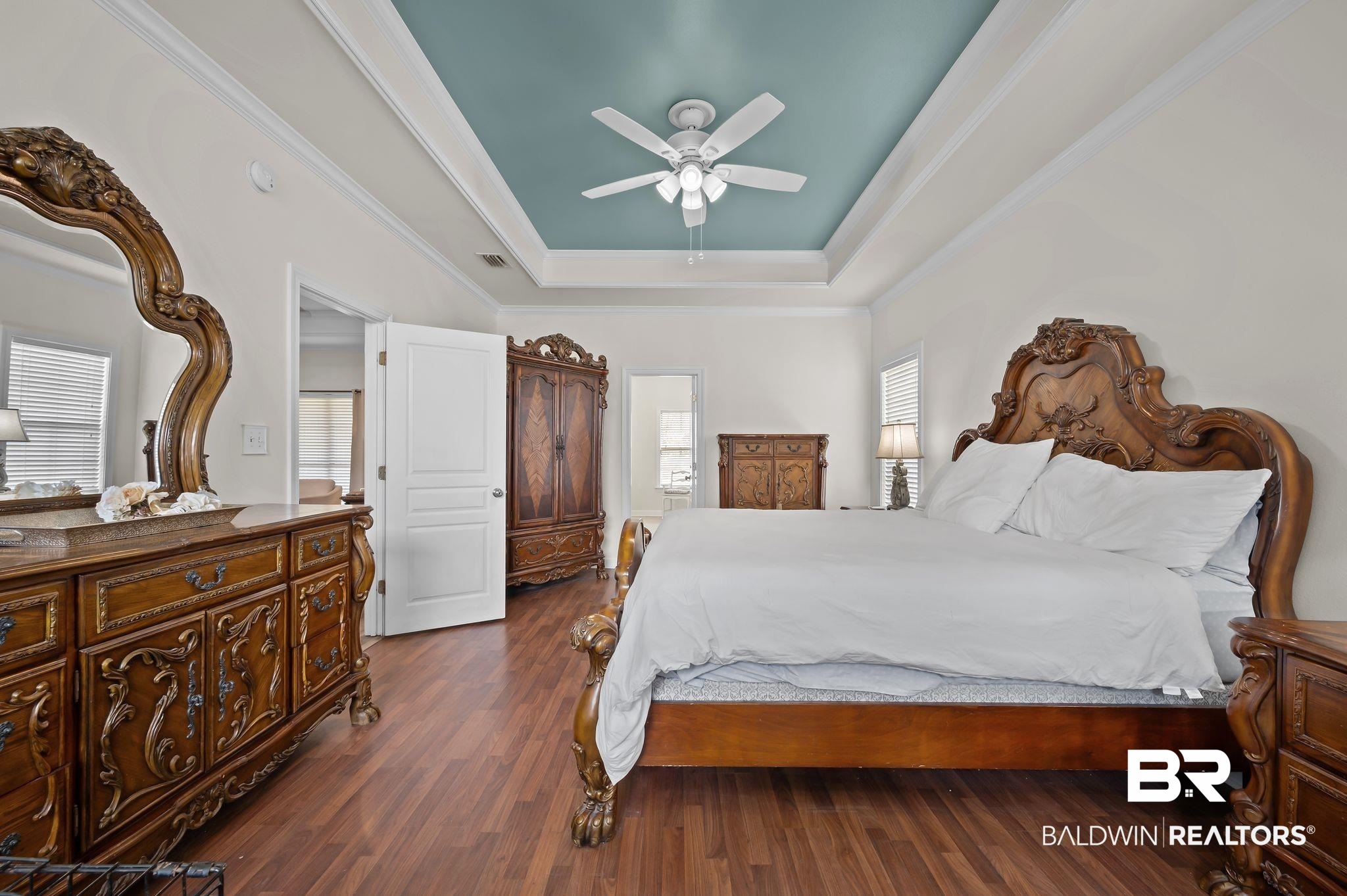 9837 Harmony Ridge Drive Semmes, AL 36575 - Photo 17 of 29 Bedroom with a tray ceiling, multiple windows, crown molding, and dark wood-style flooring