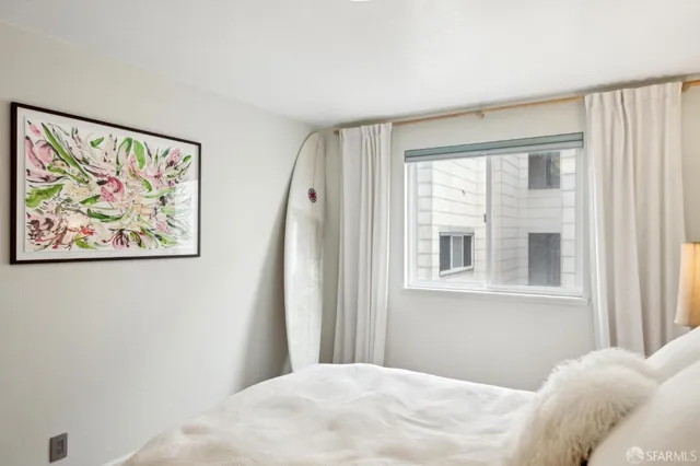 a bedroom with a bed and a painting on the wall