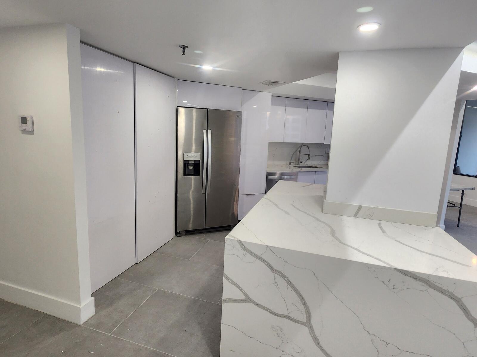 520 Brickell Key Drive, Unit A1200 Miami, FL 33131 - Photo 8 of 21 a large white kitchen with a sink and refrigerator