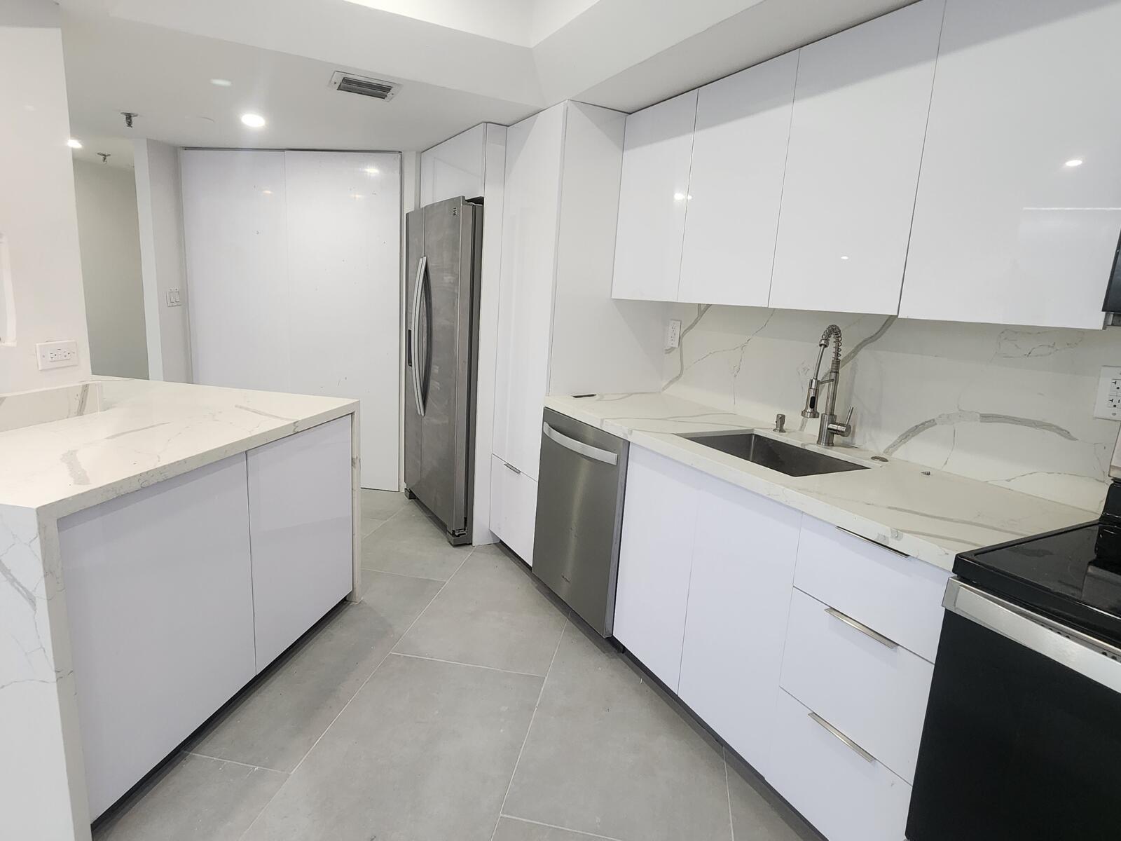520 Brickell Key Drive, Unit A1200 Miami, FL 33131 - Photo 9 of 21 a kitchen with a sink a refrigerator and cabinets