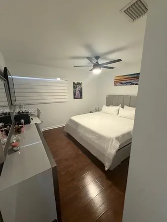 a bedroom with a bed and a flat tv screen on the dresser