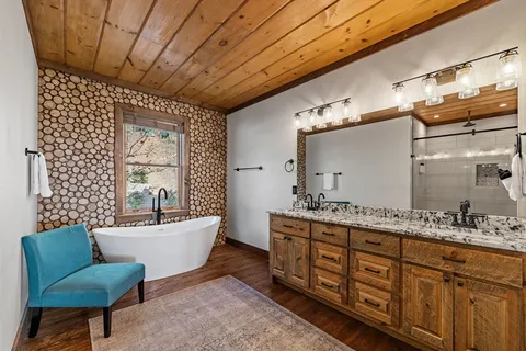 a bathroom with a double vanity sink mirror and bathtub