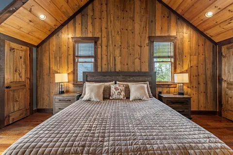 a bedroom with a large bed and wooden floor