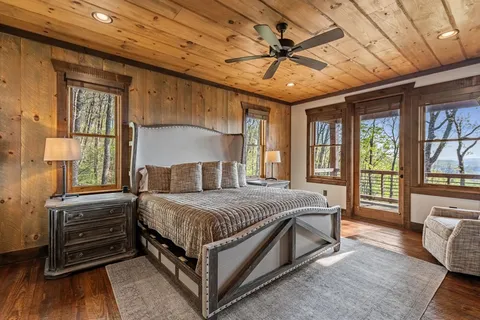 a bedroom with a bed a chandelier and next to a window