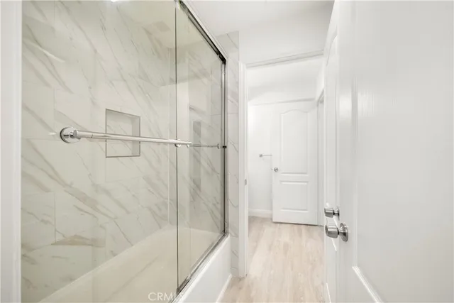 a kitchen with kitchen island granite countertop a stove a sink a refrigerator and white cabinets with wooden floor