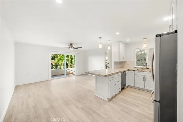 a large kitchen with a white cabinets and wooden floor