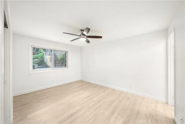 an empty room with a window and a ceiling fan