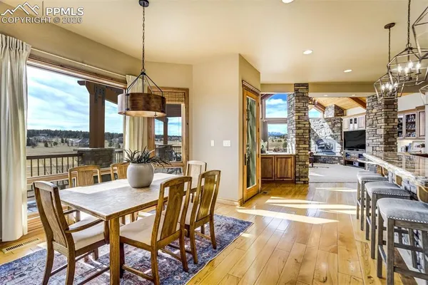 a dining room with furniture a chandelier and wooden floor