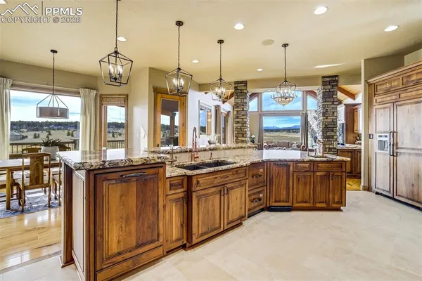 a large kitchen with granite countertop a large kitchen island in the center