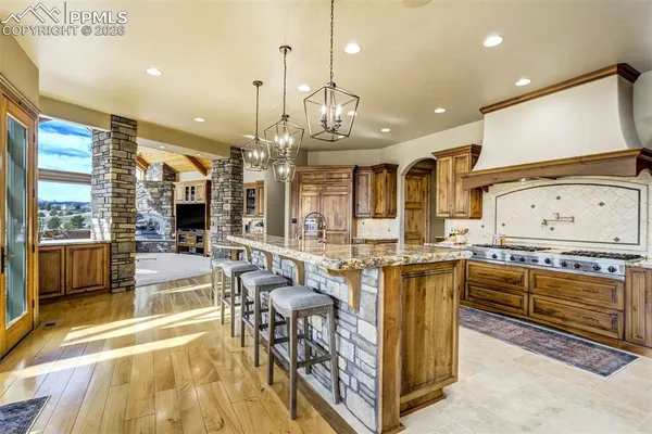a kitchen with stainless steel appliances granite countertop a stove and a view of living room