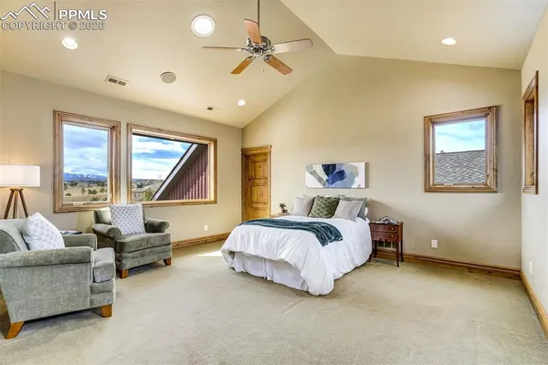 a spacious bedroom with a bed couch and window