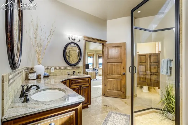 a bathroom with a granite countertop sink a mirror and shower