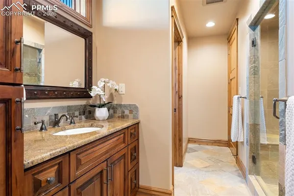 a bathroom with a granite countertop sink and a mirror