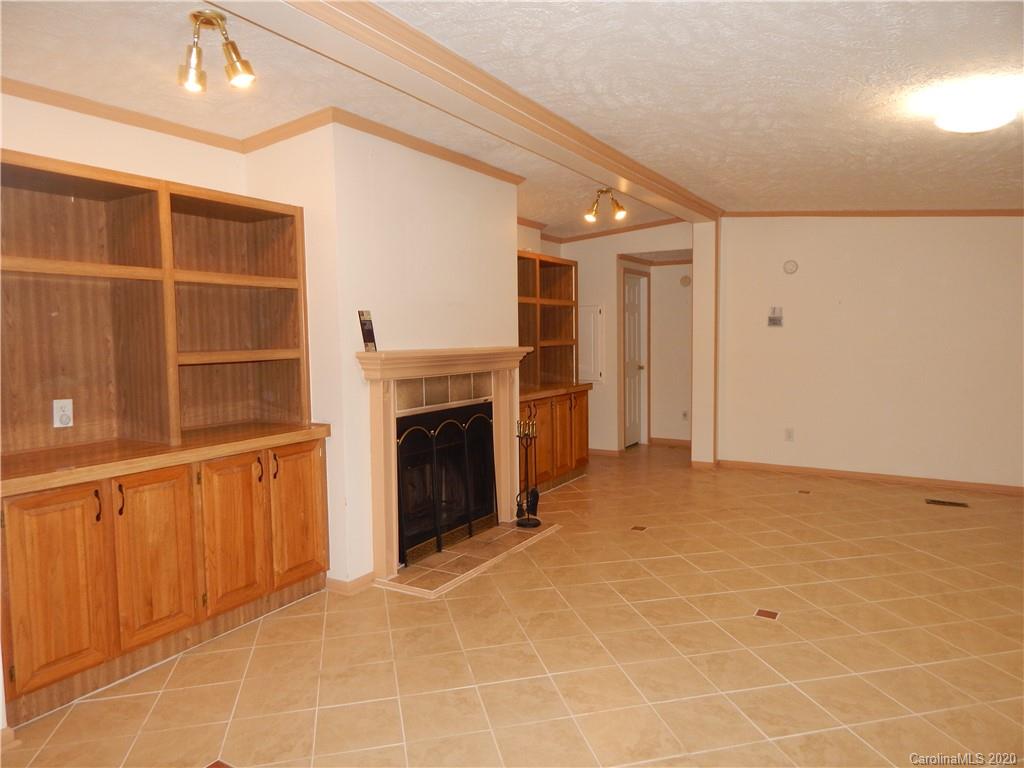 1936 Coopers Gap Road Rutherfordton, NC 28139 - Photo 12 of 32 a view of an empty room with a fireplace and a window