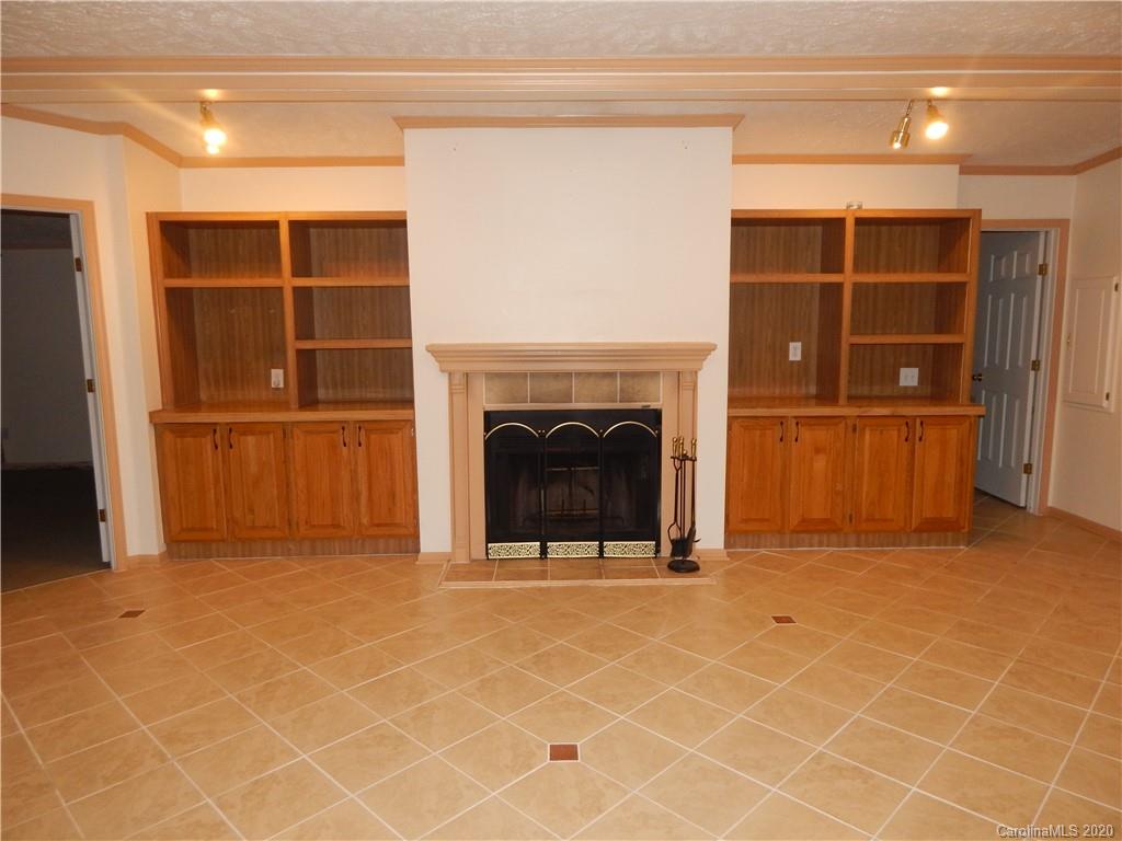 1936 Coopers Gap Road Rutherfordton, NC 28139 - Photo 14 of 32 an empty room with a fireplace and cabinet