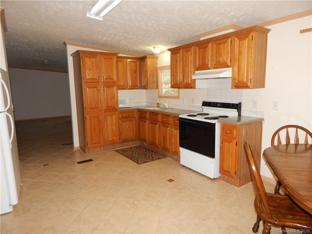 1936 Coopers Gap Road Rutherfordton, NC 28139 - Photo 8 of 32 a kitchen with stainless steel appliances granite countertop a stove a sink a refrigerator with a dining table and chairs
