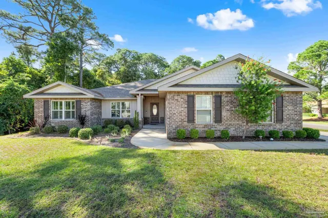 a front view of a house with yard and green space