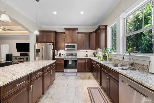 a large kitchen with kitchen island granite countertop a large counter top a sink stainless steel appliances and cabinets