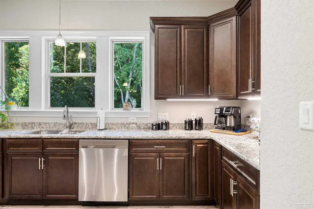 a kitchen with stainless steel appliances granite countertop a sink stove and cabinets