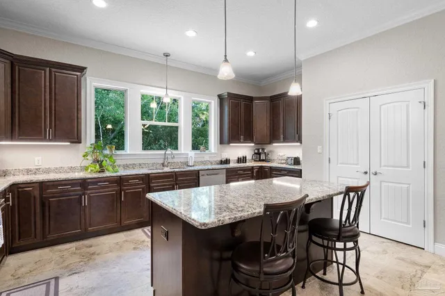 a kitchen with granite countertop a table chairs sink and cabinets