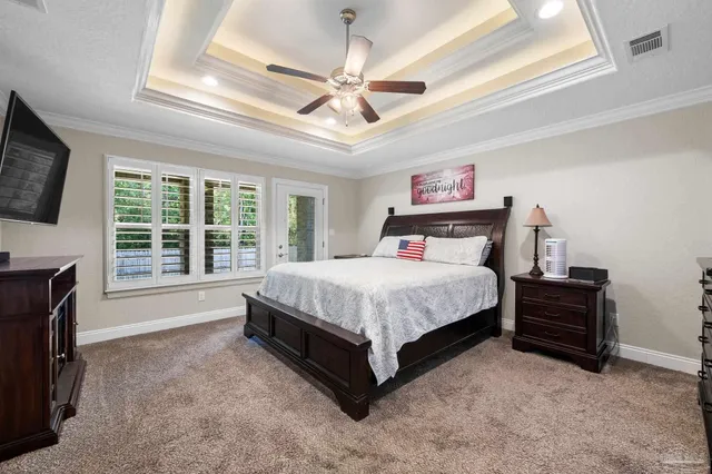 a spacious bedroom with a bed and a flat tv screen on dresser
