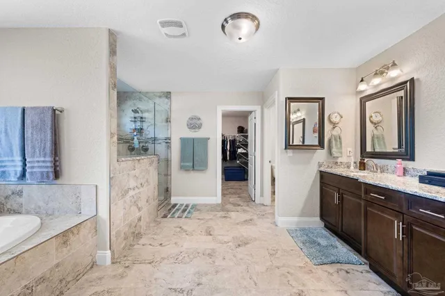 a spacious bathroom with a bathtub sink and mirror