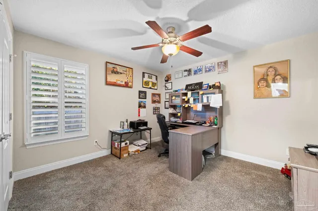 a view of a workspace with furniture and a window