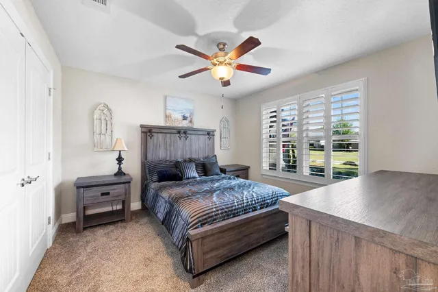 a bedroom with a bed and a large window with a chandelier