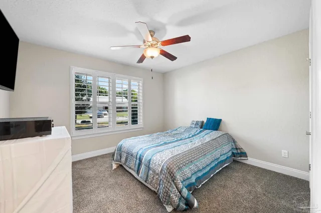 a bedroom with a white bed and a large window