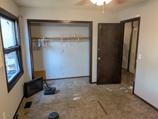 an empty room with windows and cabinet