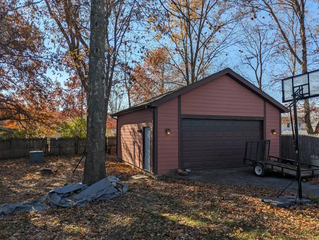 a view of a backyard with large trees and a barn