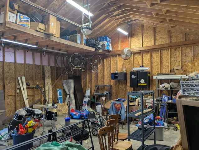 a view of wooden house with a large window and wooden fence