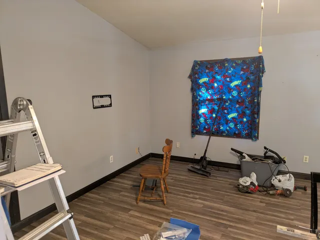 a room with gym equipment and wooden floor