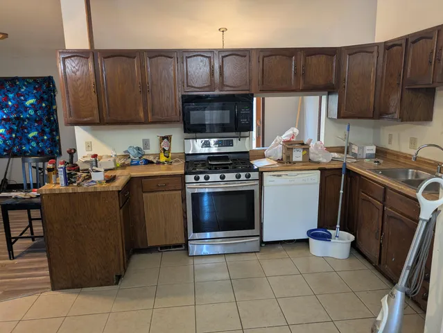 a kitchen with a sink a stove and cabinets