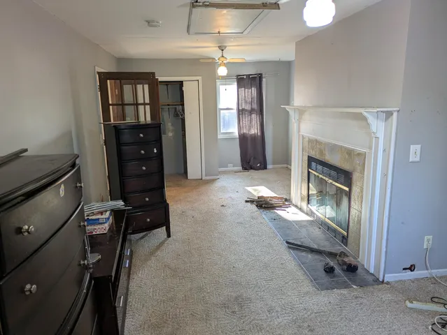 a furnished livingroom with a fireplace and windows