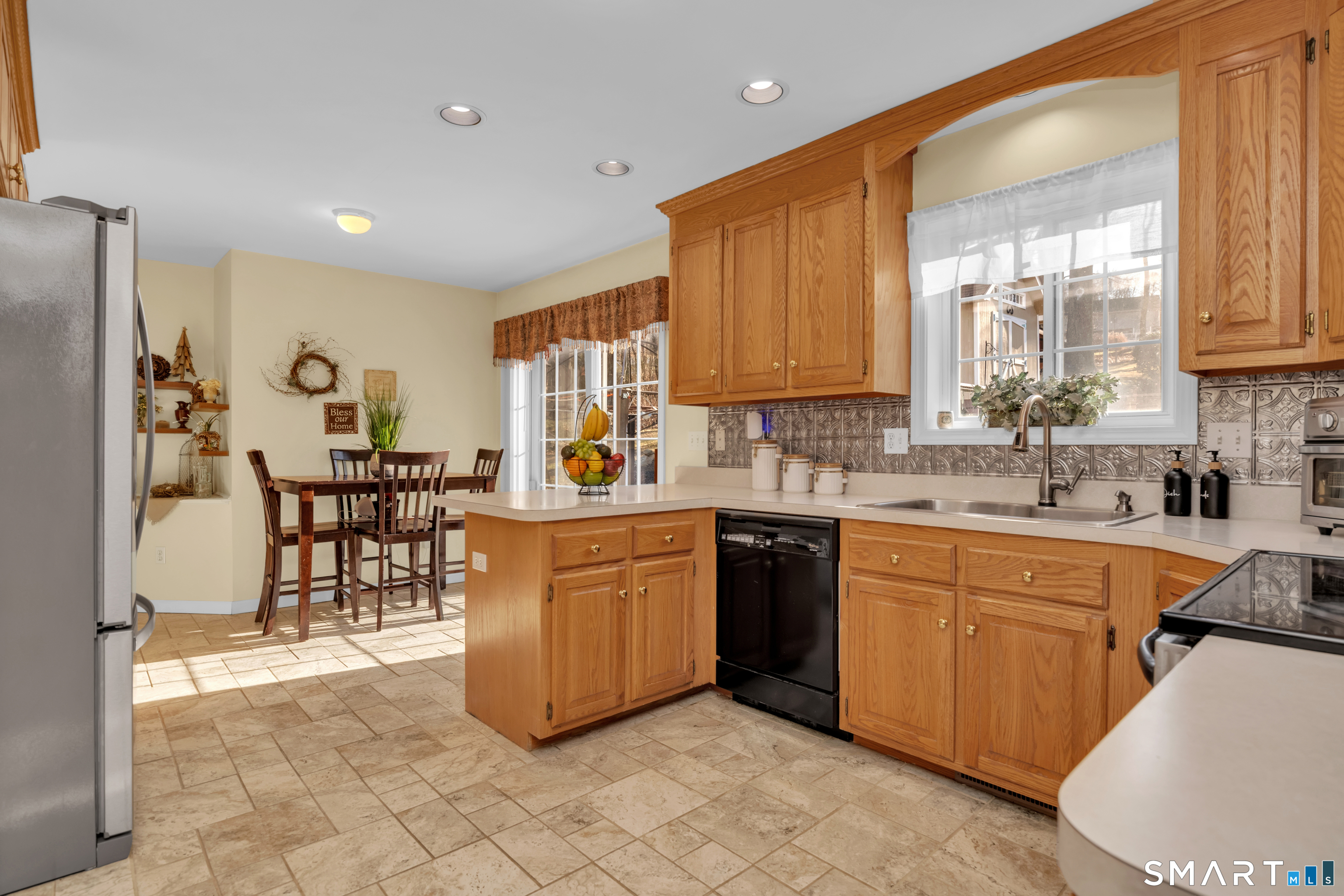 138 Burton Road Beacon Falls, CT 06403 - Photo 12 of 40 a kitchen with stainless steel appliances granite countertop a refrigerator a sink dishwasher a dining table and chairs with wooden floor