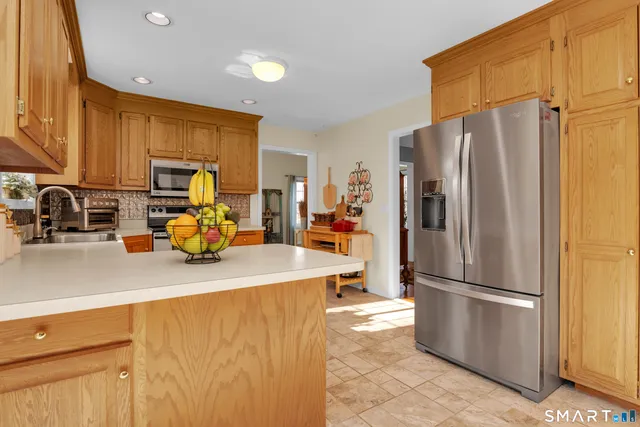 a kitchen with a refrigerator a stove and a sink with wooden floor